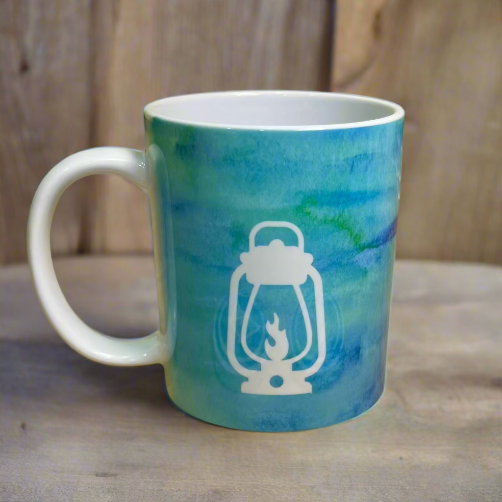 Blue and green swirl together in this tie-dye blue sky inspired happy glamper mug with the Glamping Essentials logo in white