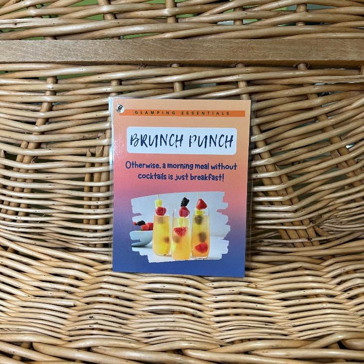 The contents of the Spring 2024 Glamping Box: Brunch Punch laminated drink recipe card