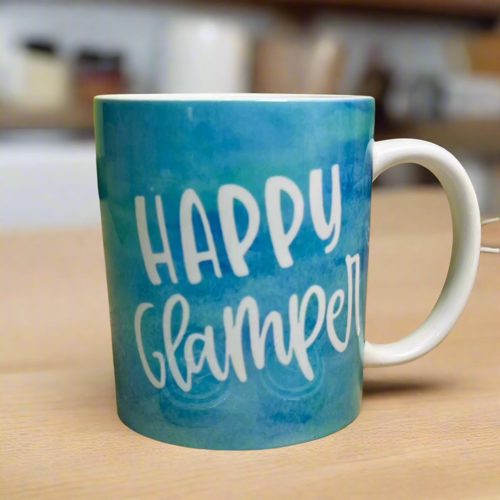 Blue and green swirl together in this tie-dye blue sky inspired happy glamper mug with the words Happy Glamper in white