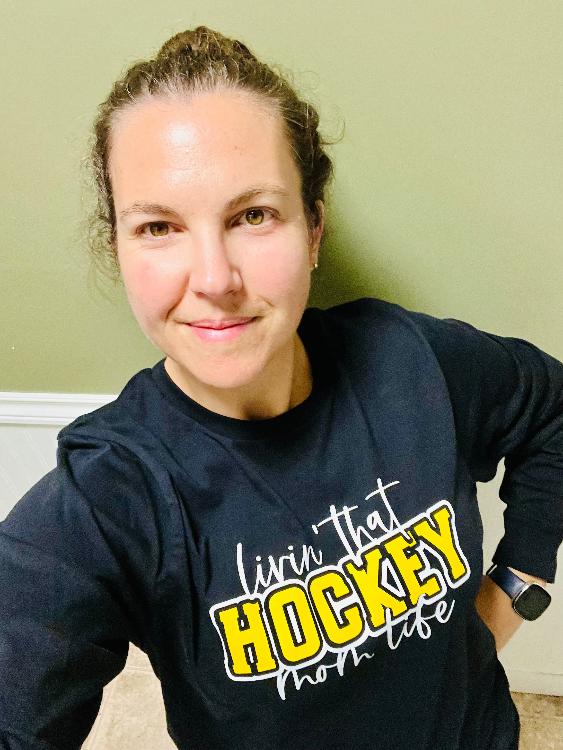 Black long sleeve tee says "livin that Hockey mom life' in white on the front