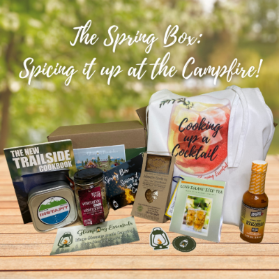 A collection of items from the Spring Box: The New Trailside cookbook, an InstaPit, Vegetarian chili from Recipes in a Jar, Spices, hot sauce, a fancy apron, drink recipe, stickers and more!