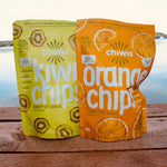 Load image into Gallery viewer, Pictured here are two bags of Chiwis nature fruit snack chips!  One bag is green and had kiwi chips, the other is orange and has orange chips.  They were part of the July Glamping Box.
