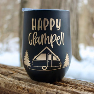 This is a black Glampy insulated wine tumbler with the saying "Happy Glamper" written in gold font over an A-Frame trailer nestled between two trees.  Quite cute!