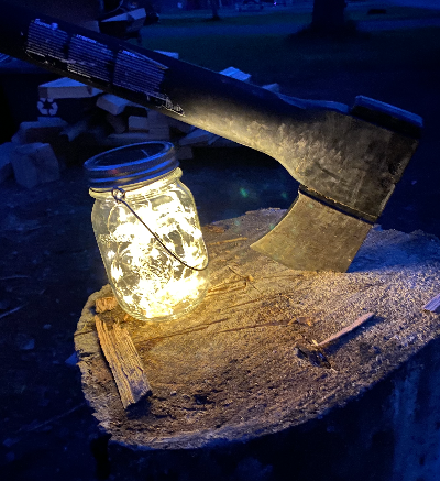 Here's the solar lantern in action at a campsite. The lantern is glowing on a chopping block, lighting an ax. These mason-jar solar lanterns were included in the August Glamping Essential's Box.