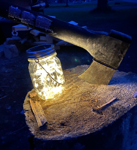 Solar lantern made from a mason jar and fairy lights.  It has a silver lid and thin metal band to hand it from a tree, clothesline or whatever you need to hang it from.  A true Glamping essential.