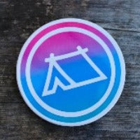 Round ceramic coasters, 100% customizable. This one has a white icon of a tent in a white circle over a pink / purple / blue ombre background.
